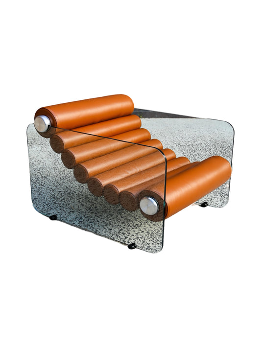 An Italian vintage armchair with tan leather rolls and a clear glass base, designed by Fabio Lenci in the 1970s.