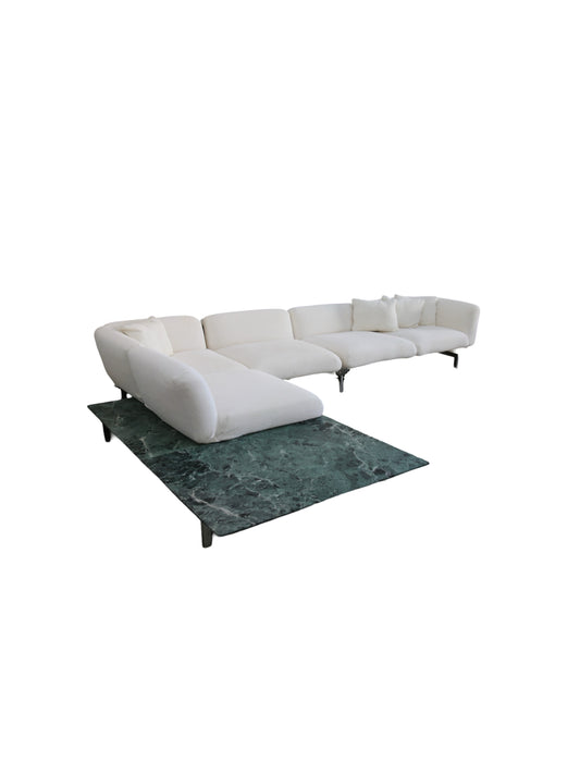 White sectional sofa on a green marble floor with a white background by Piero Lissoni for Knoll