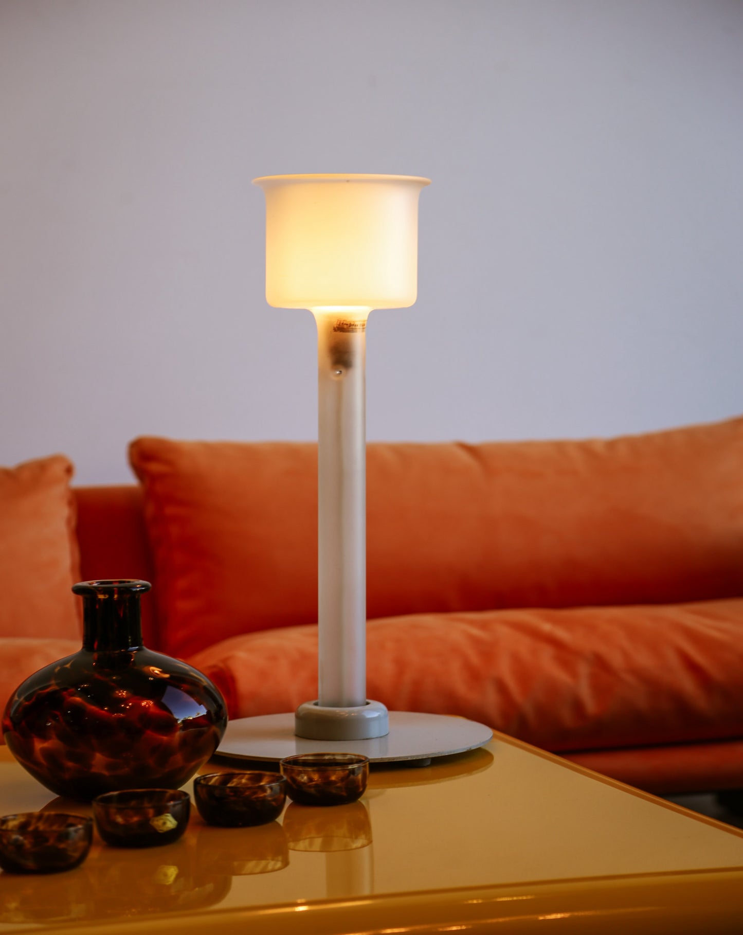 Table lamp on a coffee table with an orange sofa in the background