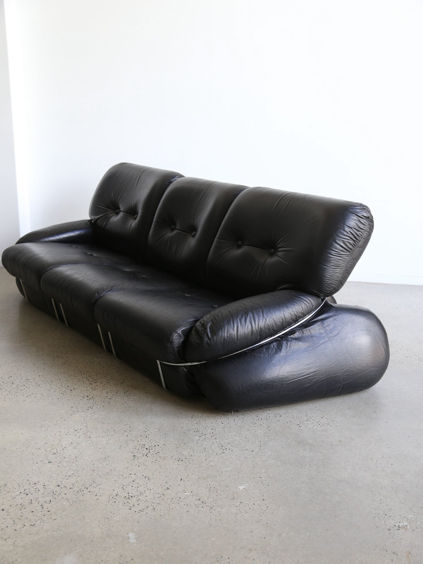 Detail of chrome frame and rounded leather cushions on Piazzesi “Okay” sofa