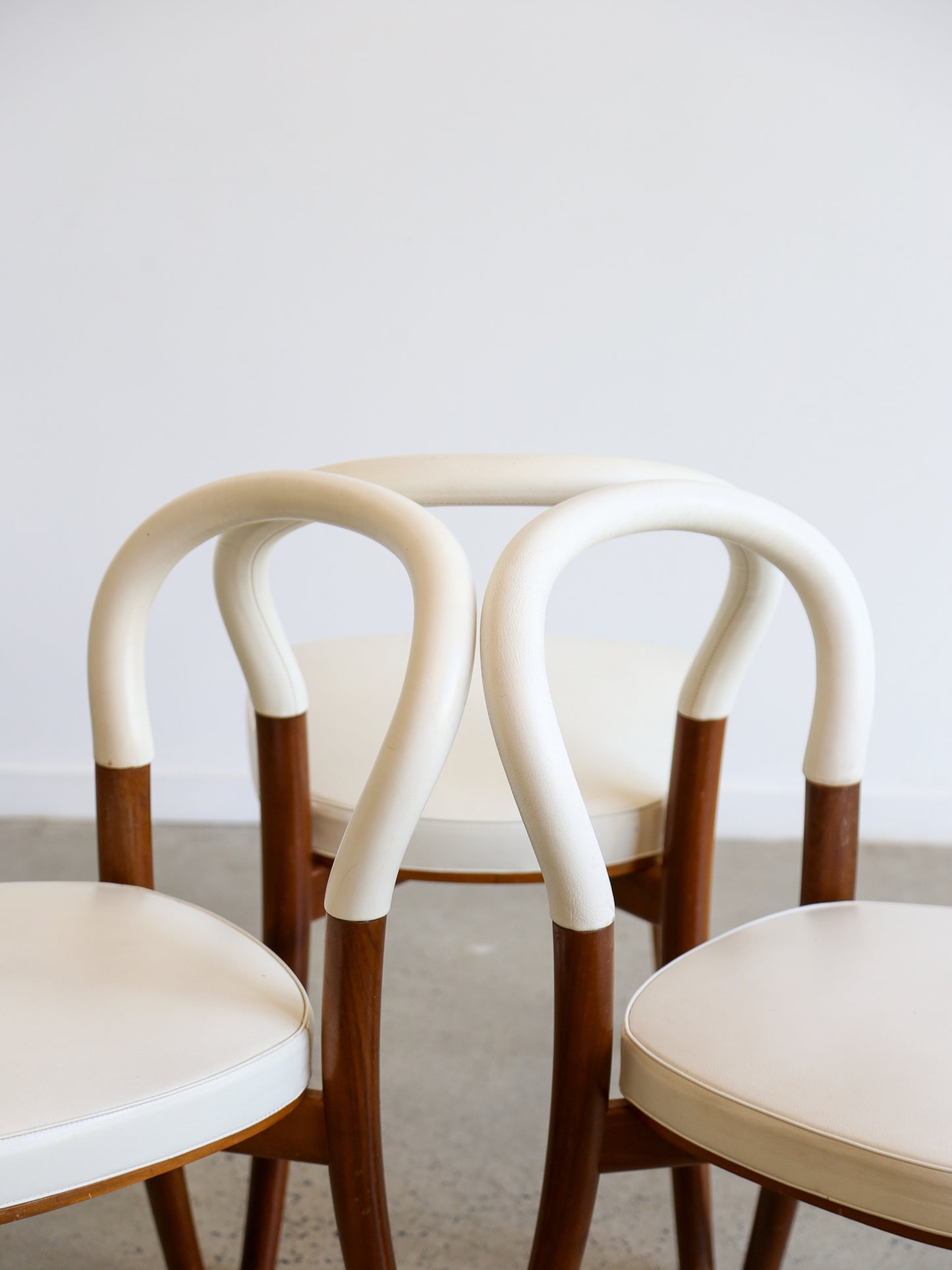 Close-up of intertwined curved backrests on Cassina Göteborg dining chairs by Erik Gunnar Asplund