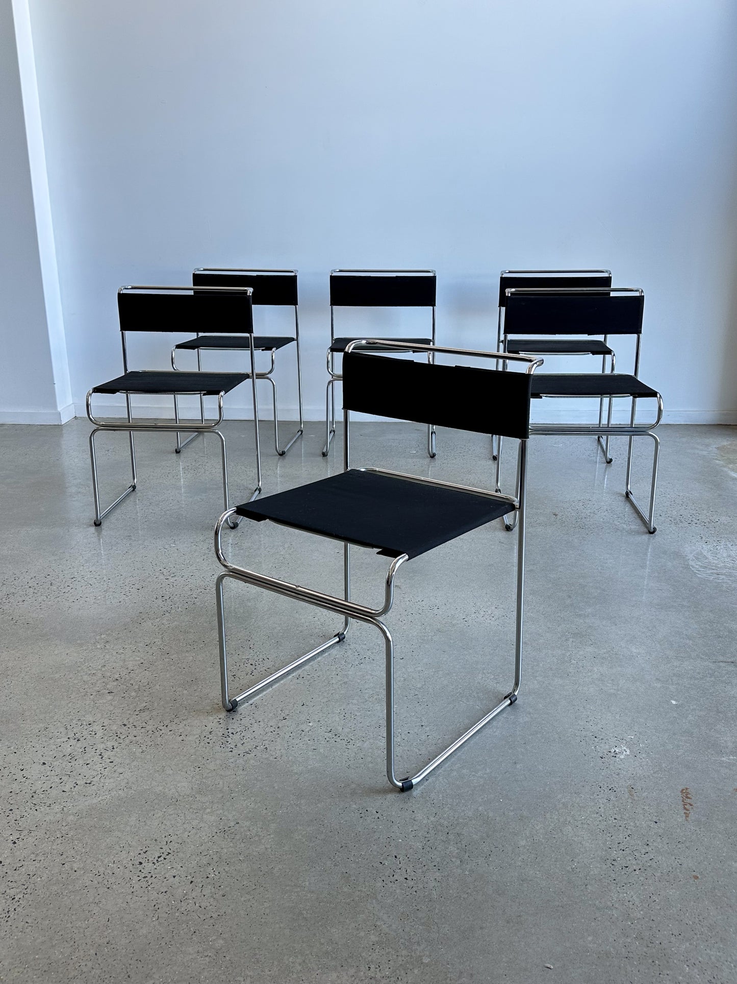 Stackable Italian mid-century chrome dining chairs with black fabric seats, Giovanni Carini for Planula