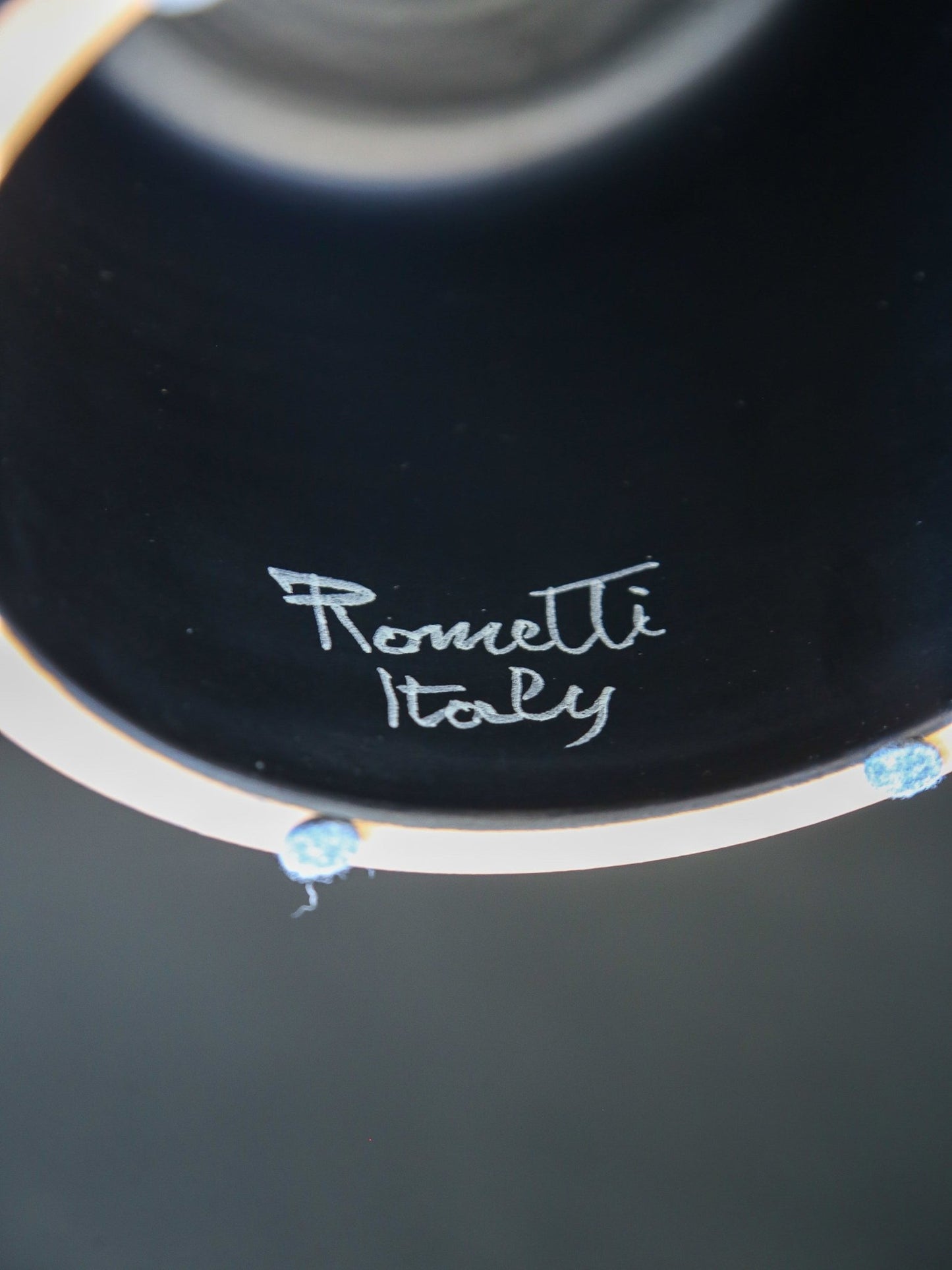 Close-up of a black dish with 'Romantti Italy' branding.