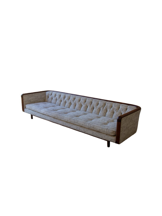 Long sofa with tufted backrest and wooden frame on a white background by Lenoir House