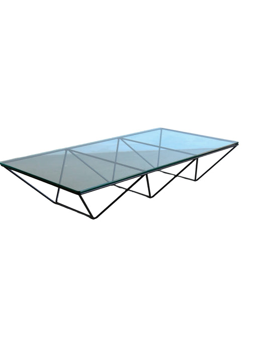 A rectangular glass coffee table with a metal frame, designed by Paolo Piva for B&B Italia.