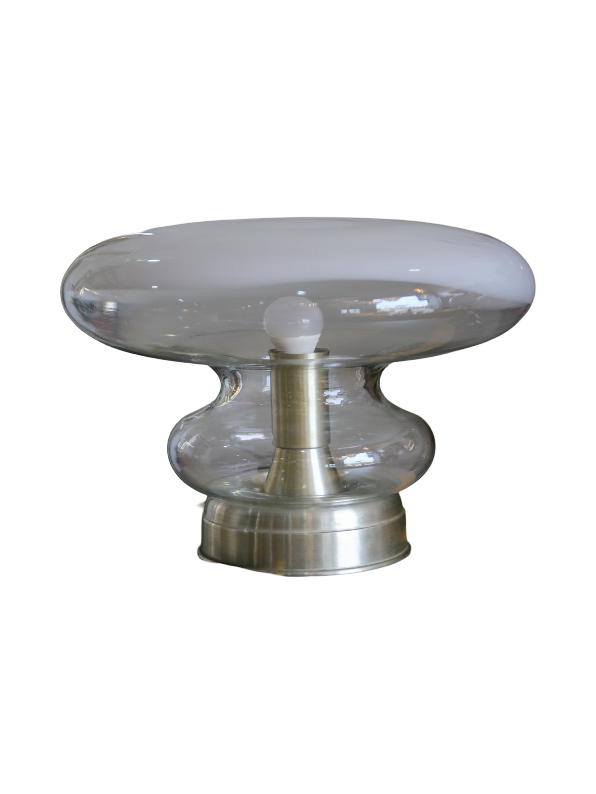 Vintage Roberto Pamio table lamp with a polished metal base and a hand-blown glass shade, displaying a soft, ambient glow.