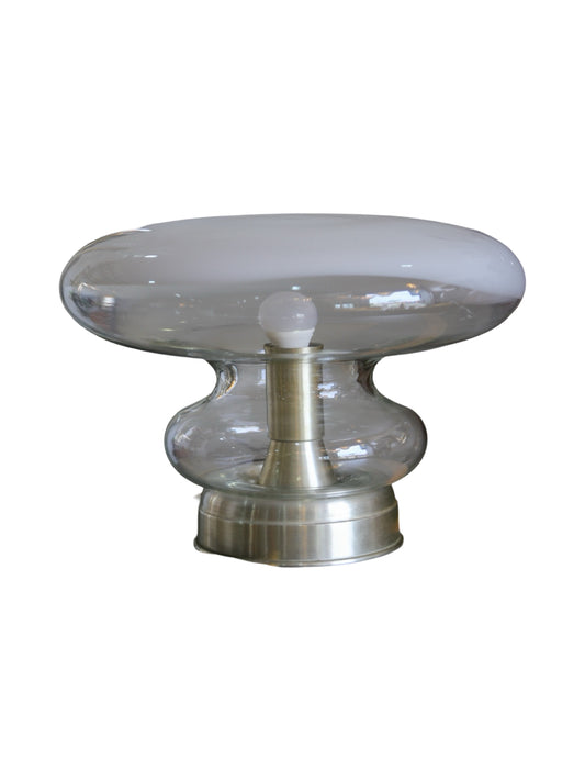 Vintage Roberto Pamio table lamp with a polished metal base and a hand-blown glass shade, displaying a soft, ambient glow.
