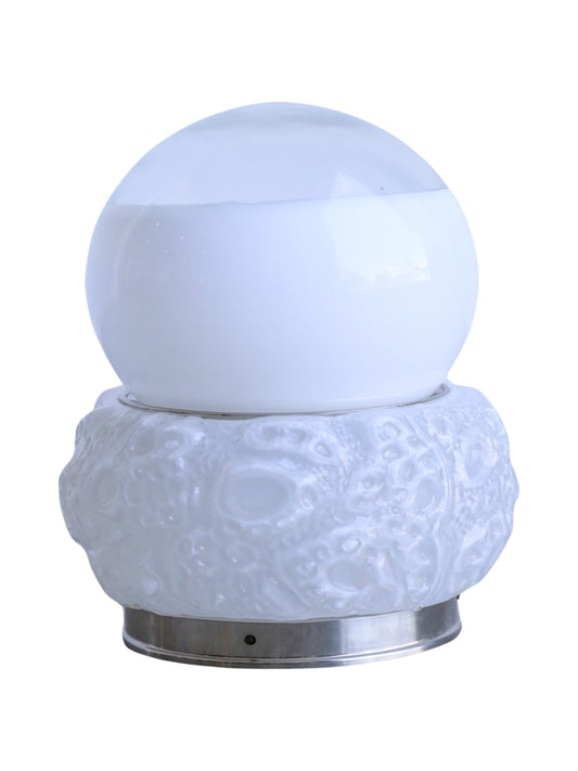 A mid-century modern table lamp with a chrome base and a Murano glass shade featuring a bone-like pattern by Mazzega