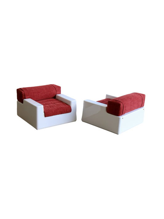 A set of two space age white fiberglass armchairs with red upholstered cushions, featuring a glossy white finish and a mechanism for extracting a bed.