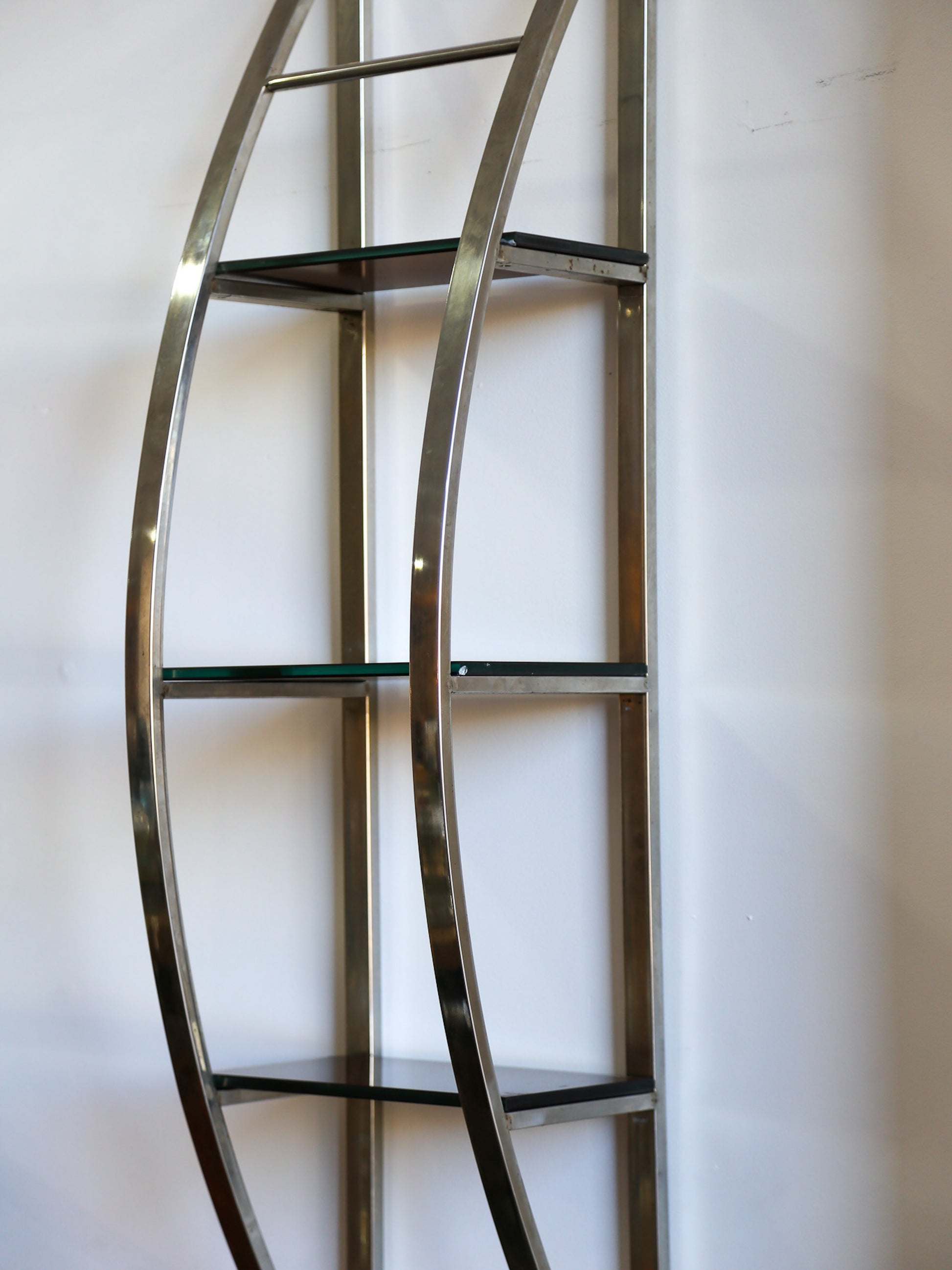 Close-up of Italian vintage chrome and glass shelf, showcasing curved frame and glass tiers