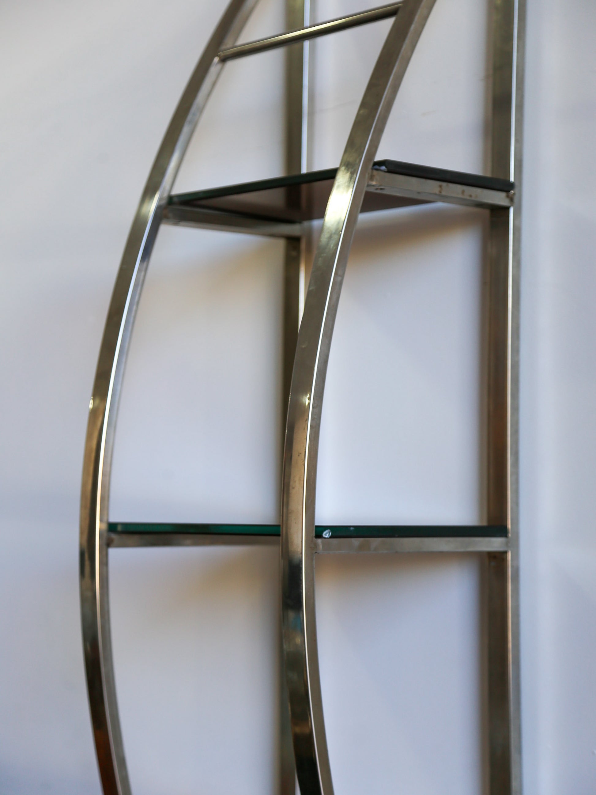 Close-up of Italian vintage chrome and glass shelf, showcasing curved frame and glass tiers