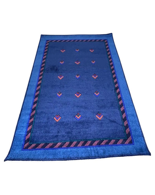 A modern wool carpet with a geometric pattern, predominantly blue with red accents, designed by Catharina Dramborg.