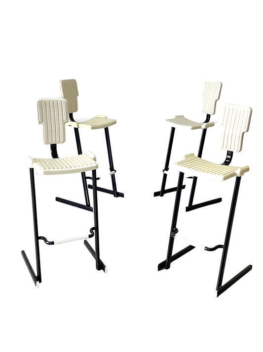 A set of four Magis Condor stools designed by Andries and Hiroko Van Onck. The stools have black metal frames and white plastic seats.