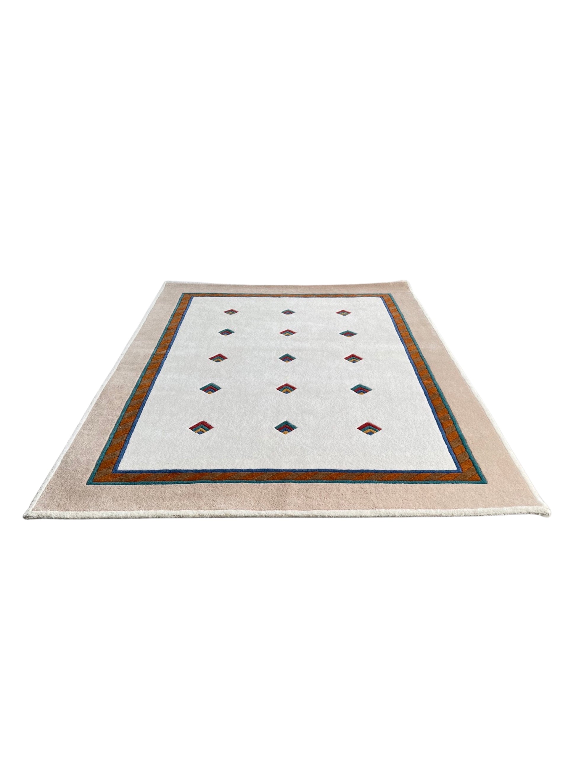 A cream-colored rectangular wool rug with a geometric pattern consisting of diamonds and a border detail.