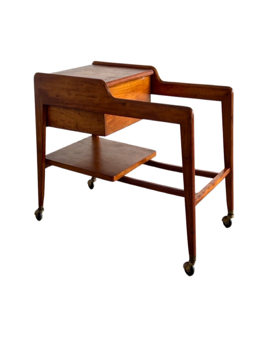 A vintage Italian teak wood trolley bar from the 1960s with two storage compartments and wheels for mobility.