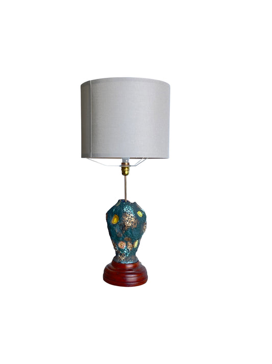 A vintage Italo Casini art lava table lamp with a colorful volcanic lava glaze ewer on a dark wood and brass steam base, replaced with a cream round shade.