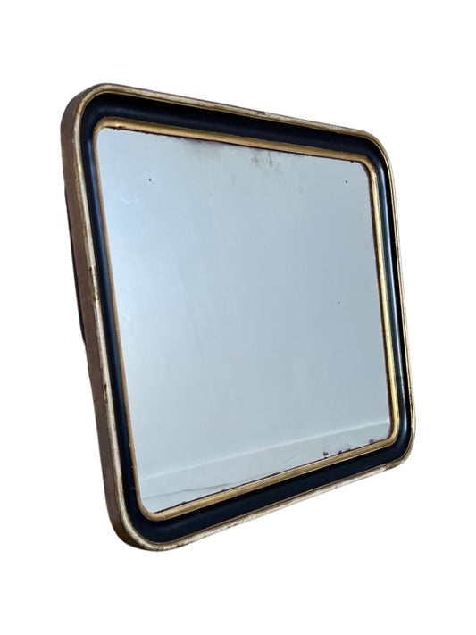 A rectangular Italian wall mirror with gold leaf work along the frame, showing signs of wear consistent with its age.