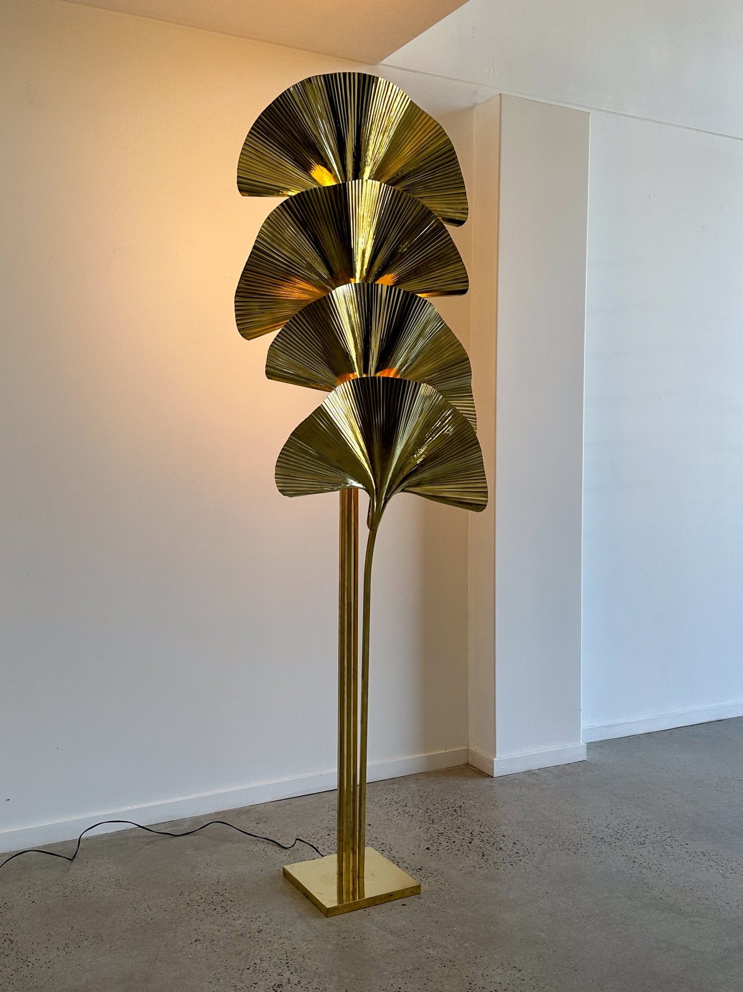 Gold leaf-shaped floor lamp against a white wall