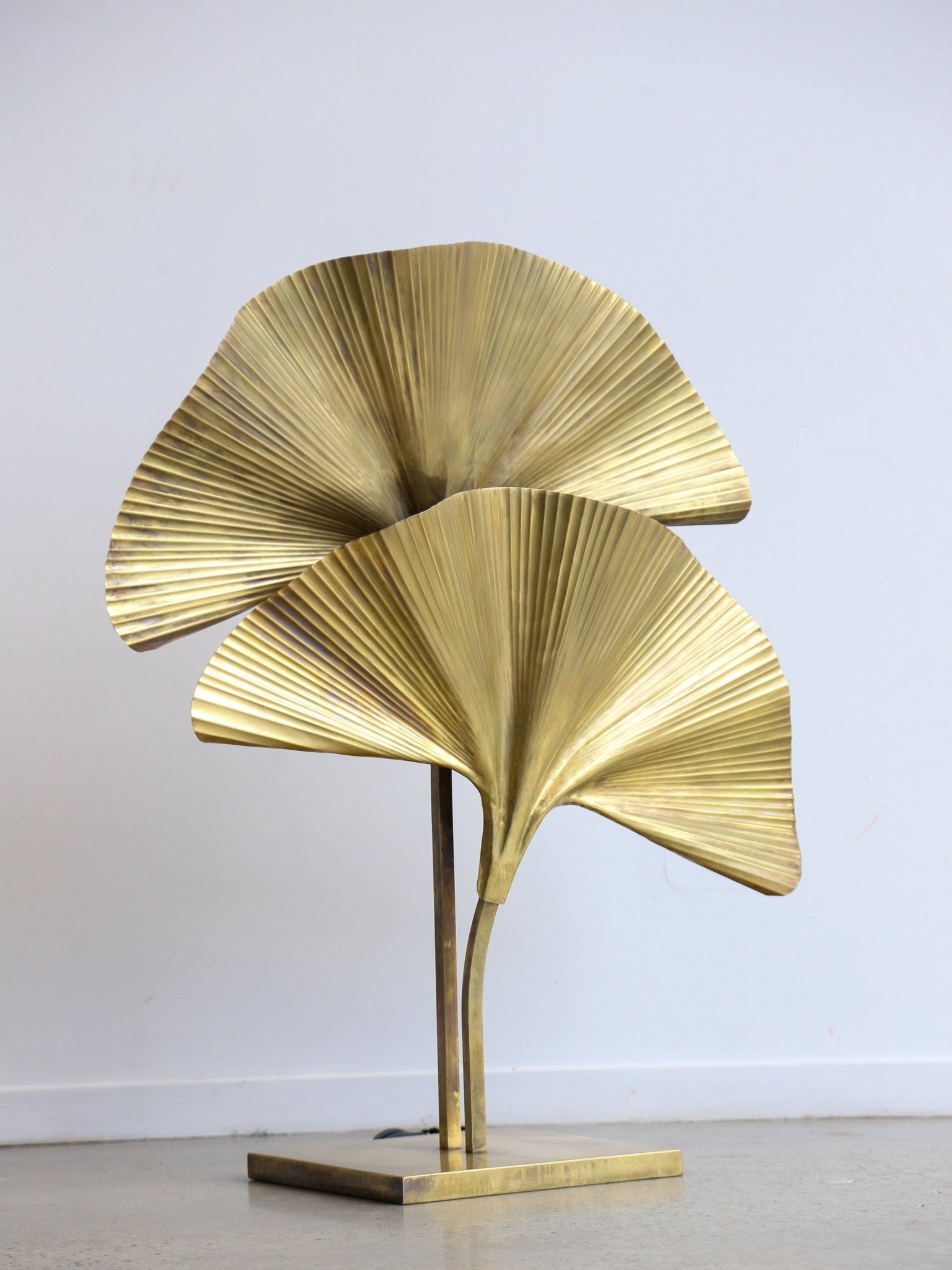Gold leaf-like sculpture on a plain background