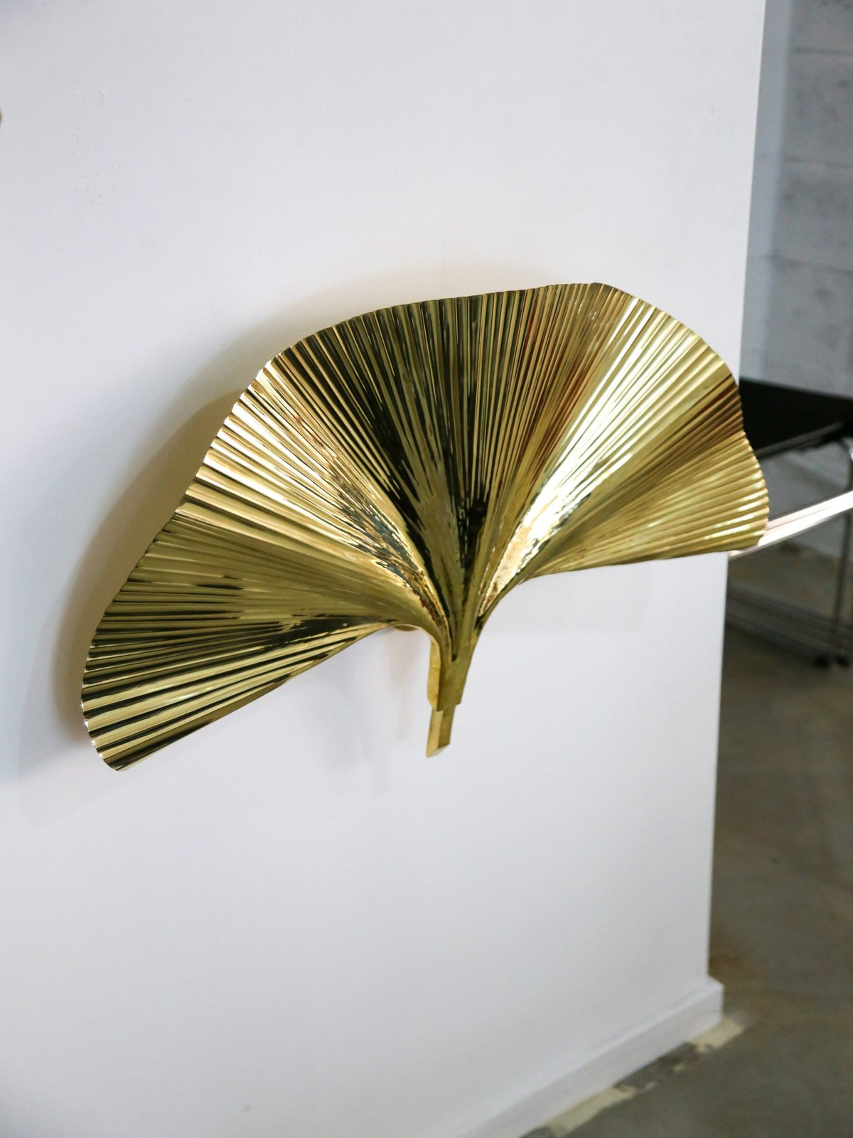 Gold leaf-shaped wall art on a white wall