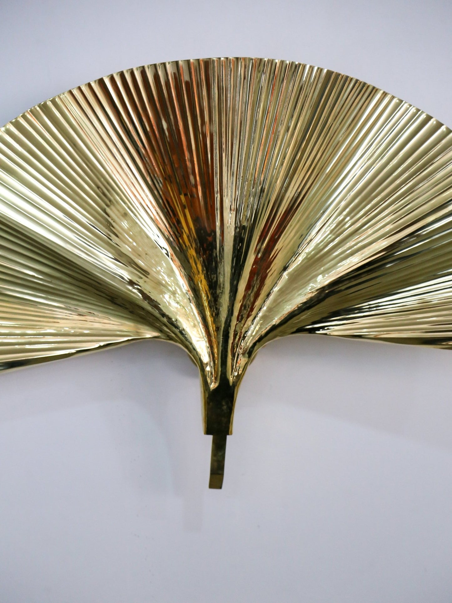 Gold leaf wall sconce on a white background