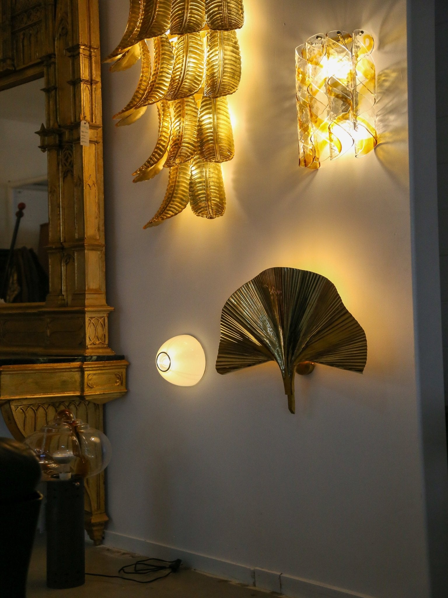 Decorative wall lights shaped like leaves on a white wall.