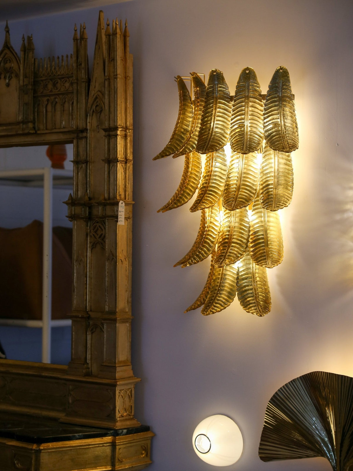 Decorative wall light fixture on a wall with architectural model in the background