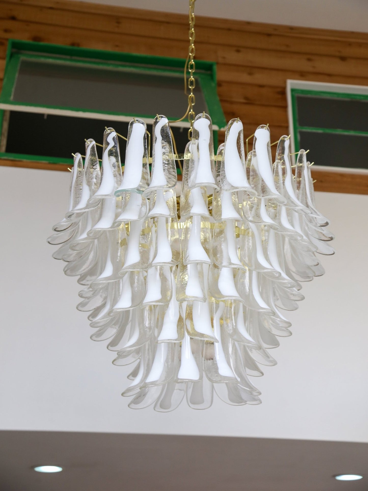 Chandelier with white glass shades hanging from a ceiling