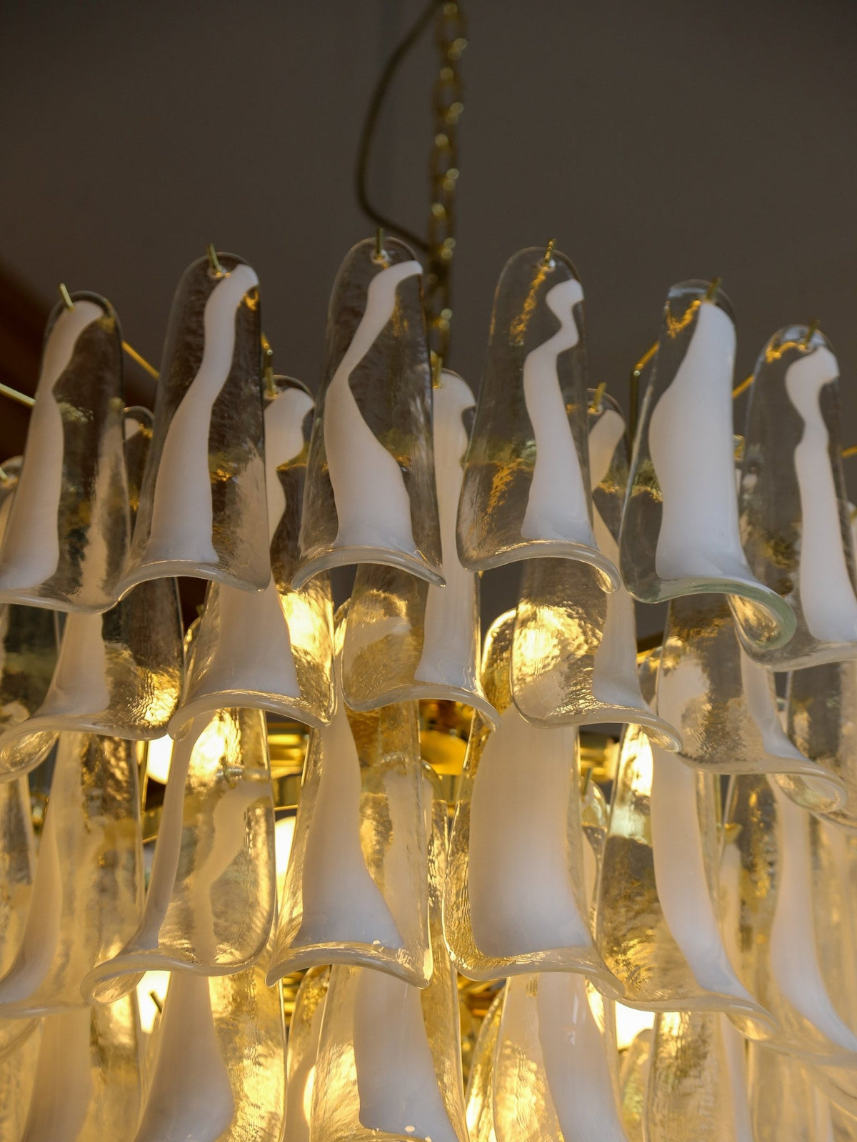 Close-up of a chandelier with glass shades and warm lighting.