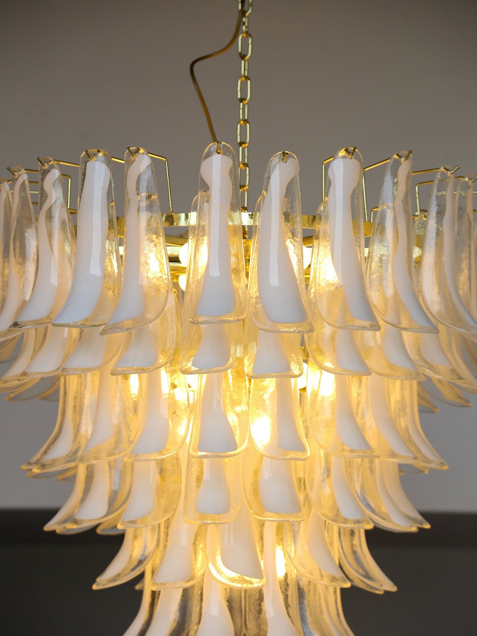 Chandelier with white glass shades and gold metal accents against a dark background