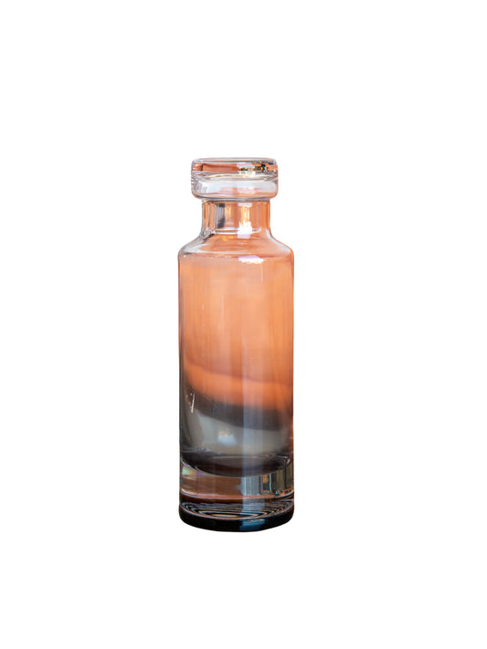 Glass bottle with gradient color from orange to black on a white background