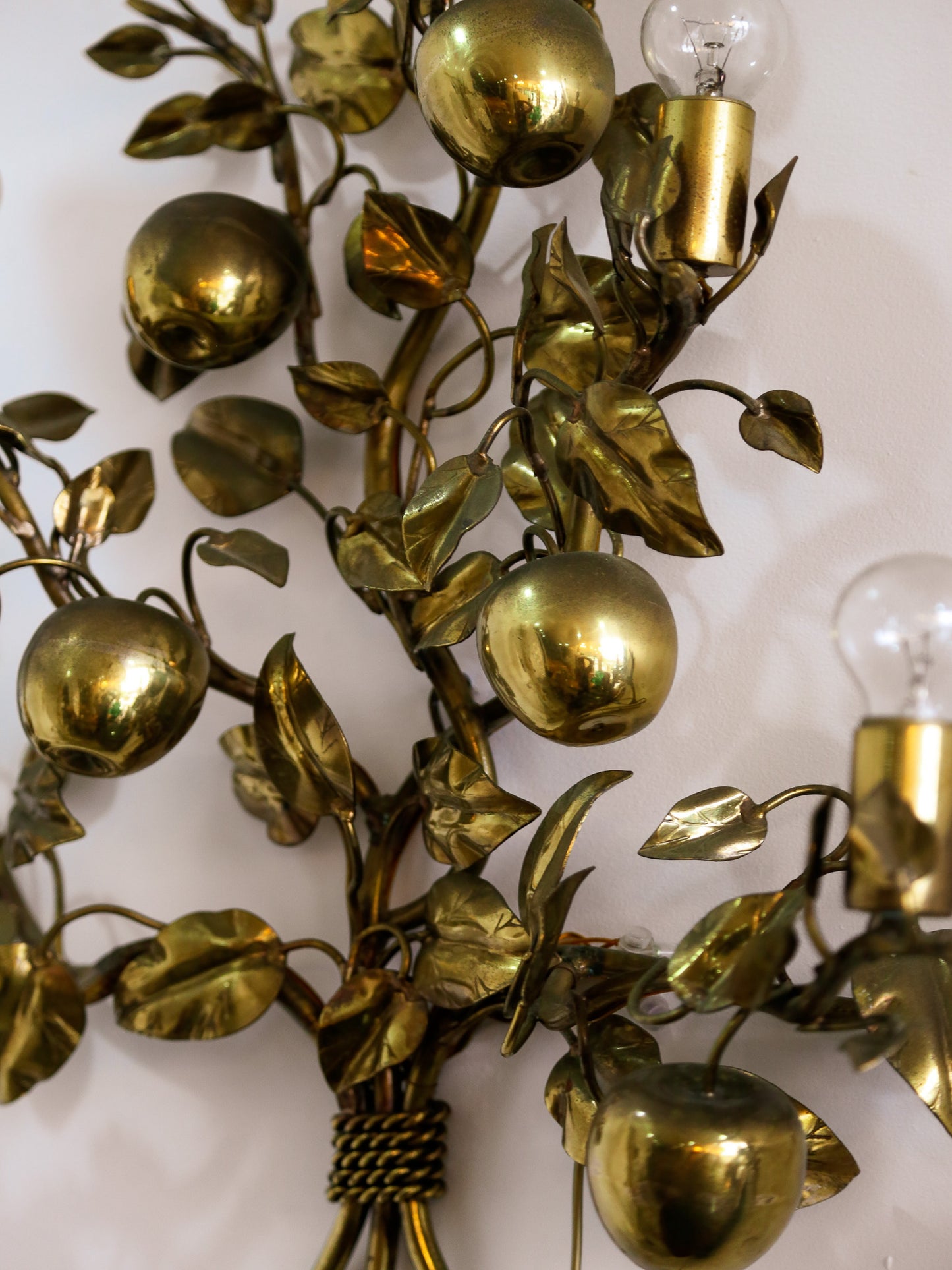 Decorative wall sconce with gold leaf and fruit design on a white background