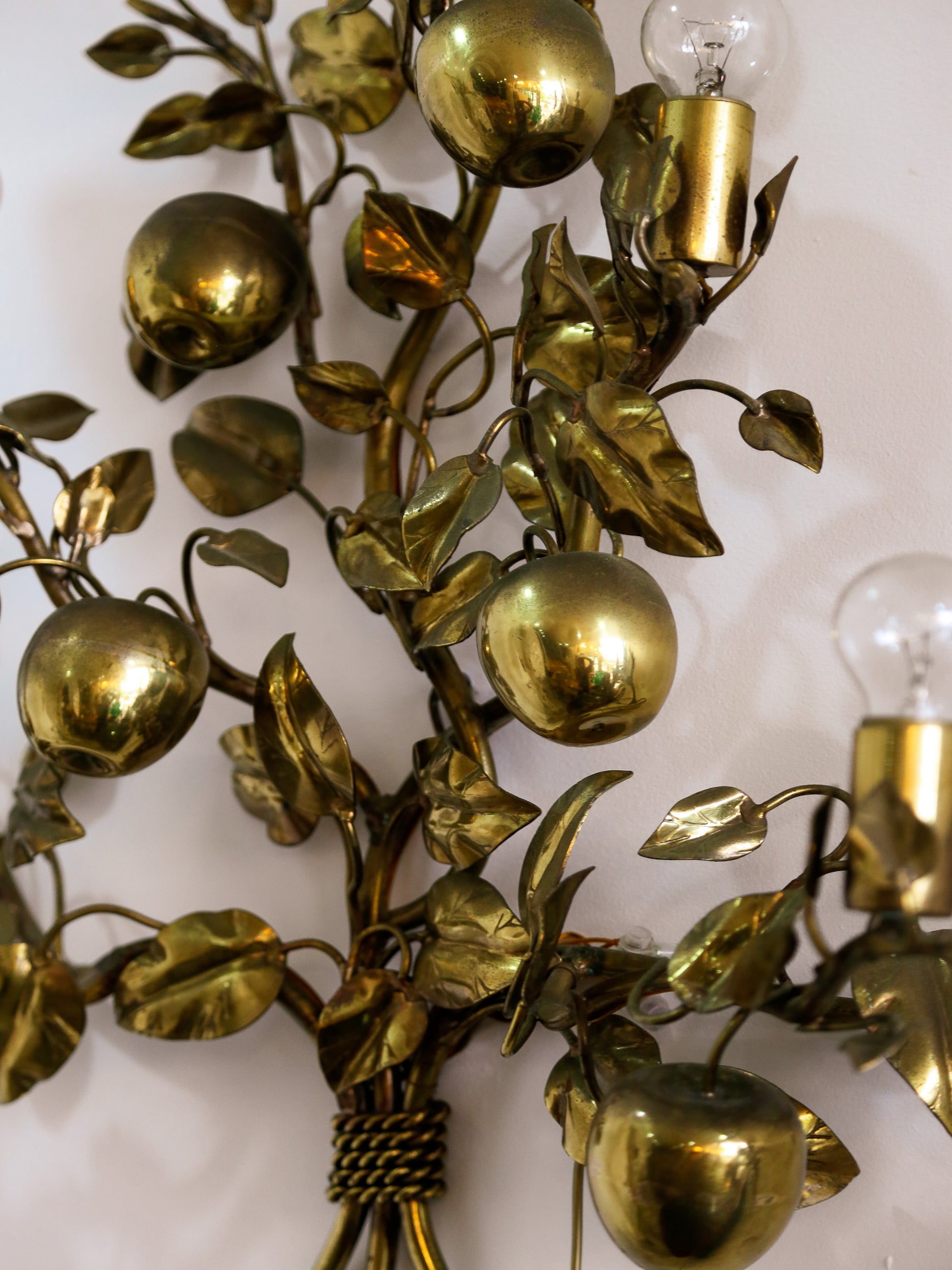 Decorative wall sconce with gold leaf and fruit design on a white background