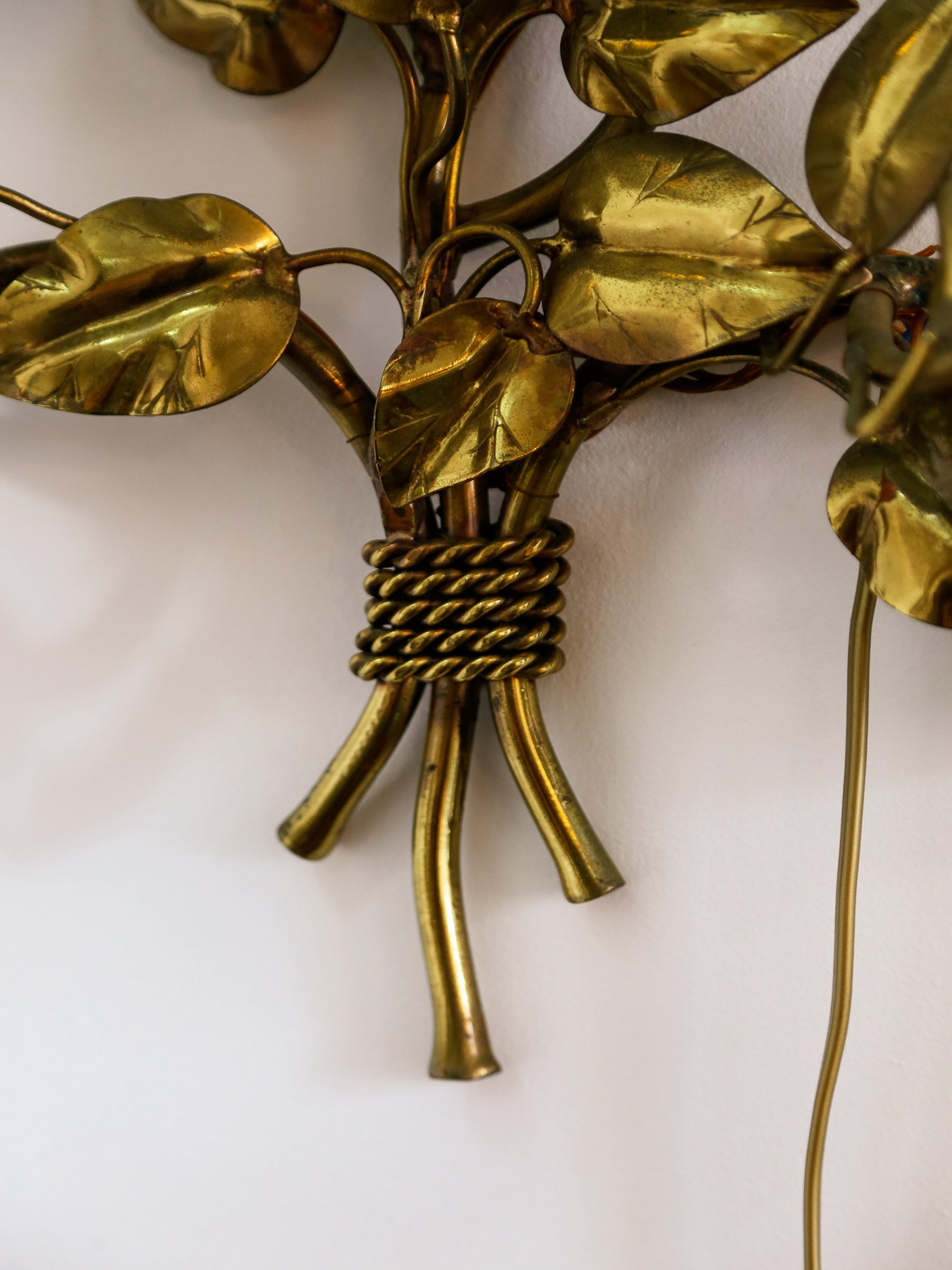 Close-up of a gold leafy decorative wall piece on a white background