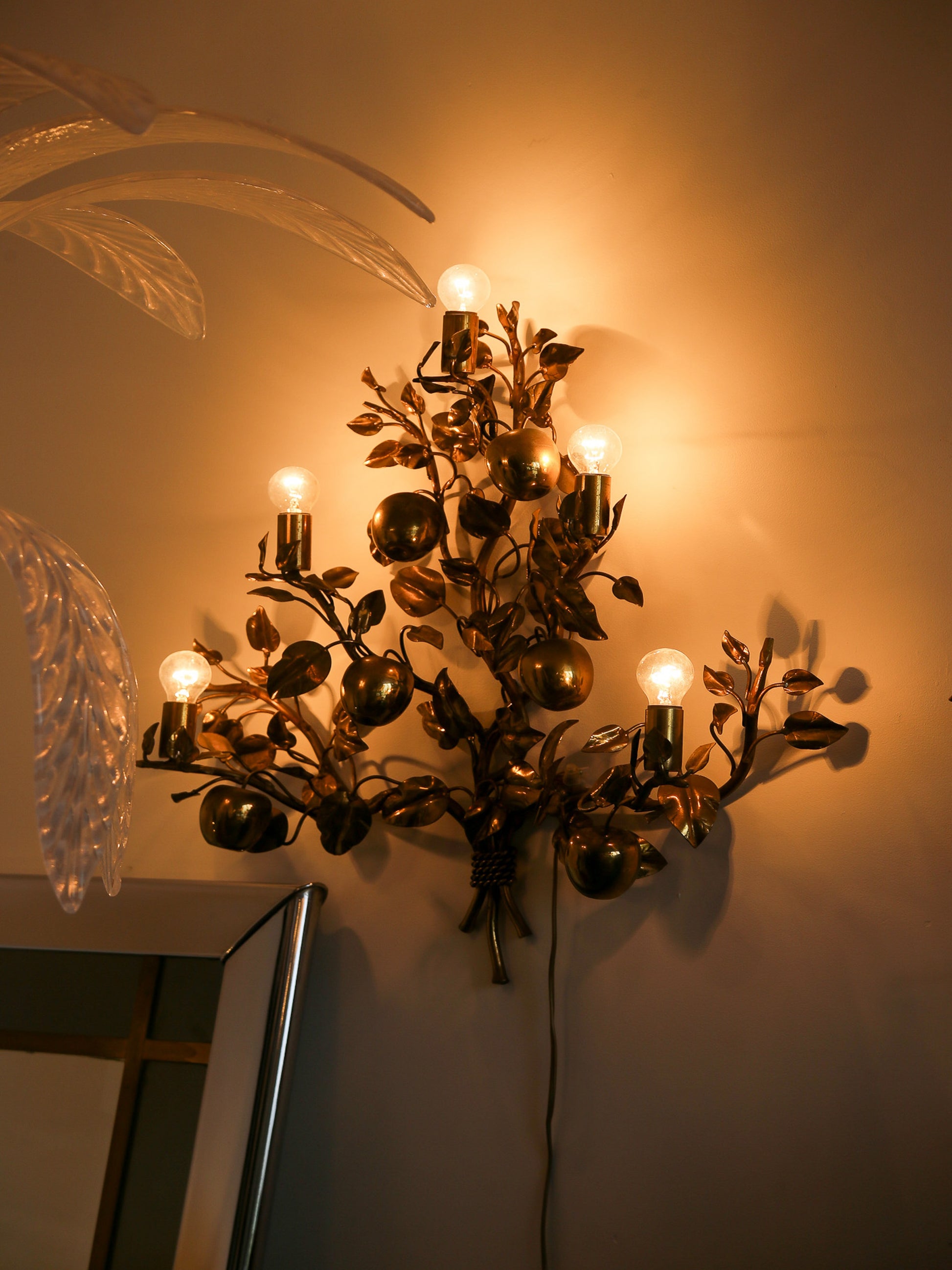 Decorative wall sconce with multiple lights on a beige wall.
