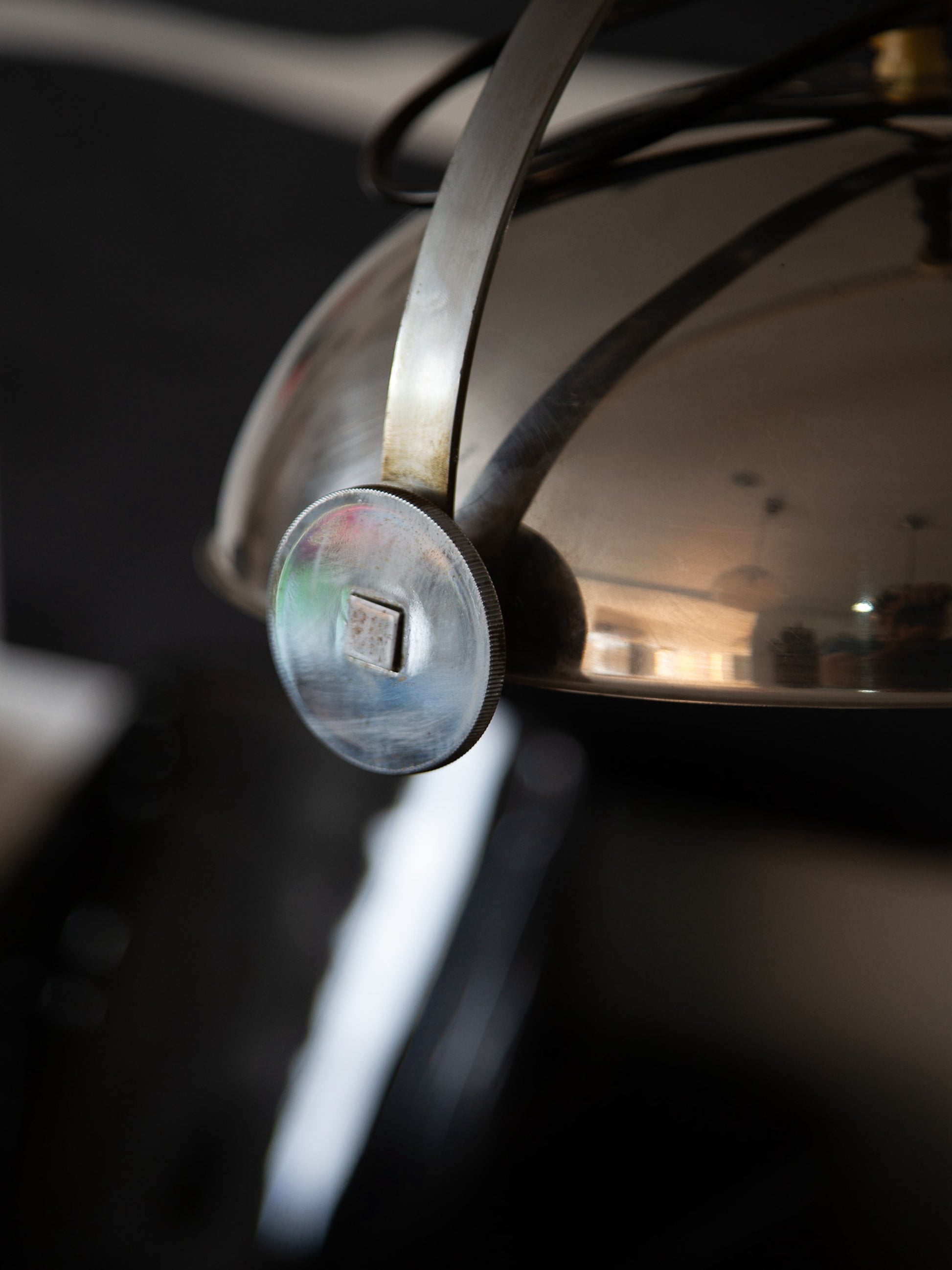 Detail of adjusting mechanism on Goffredo Reggiani chrome pendant lamp, showing brushed chrome and sculptural bracket