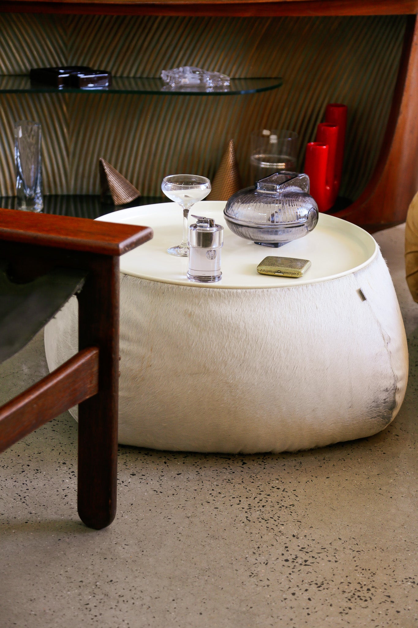 Round white ottoman with decorative items on a carpeted floor