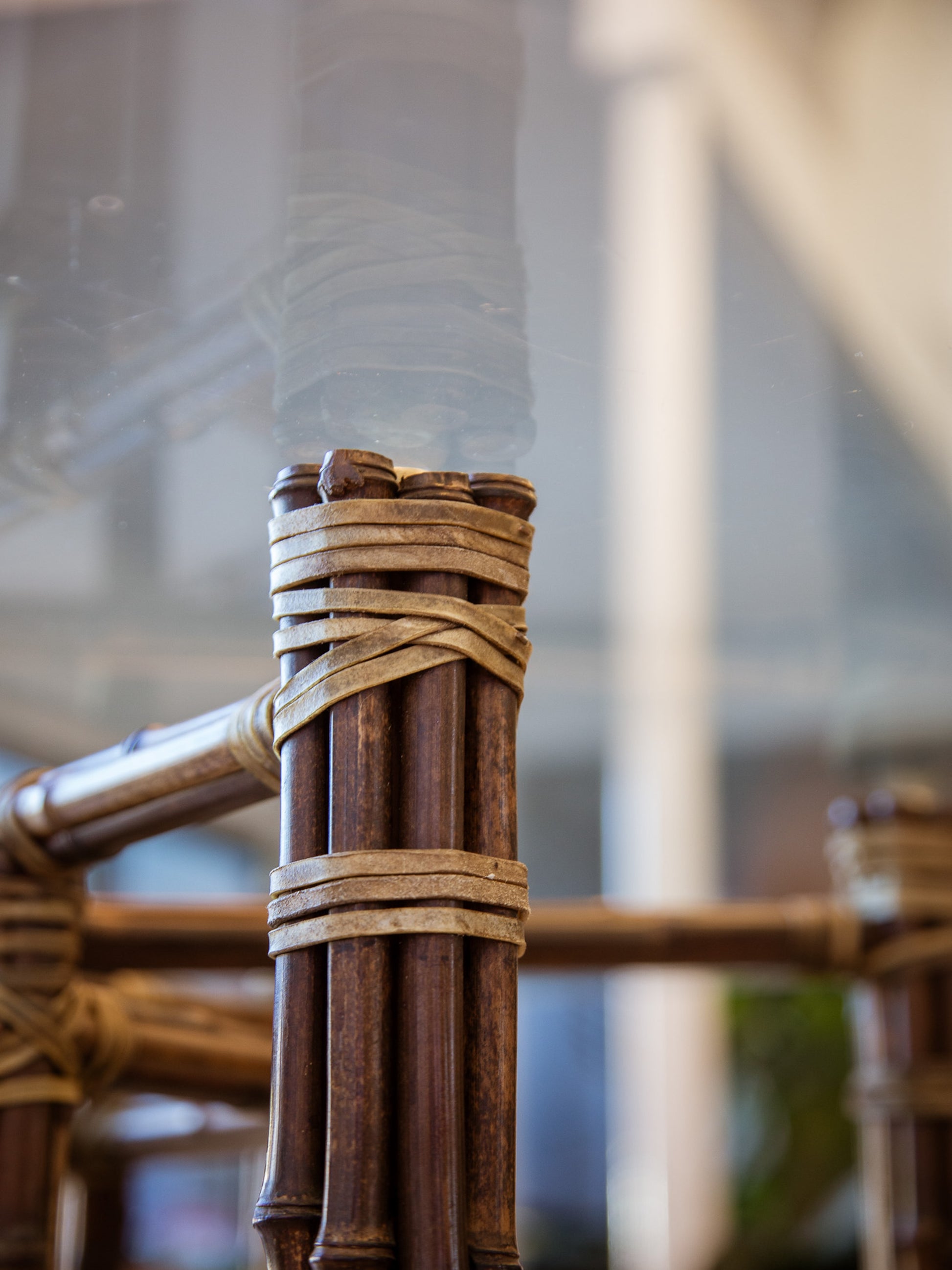 Close-up of a wooden structure with woven elements against a blurred indoor background