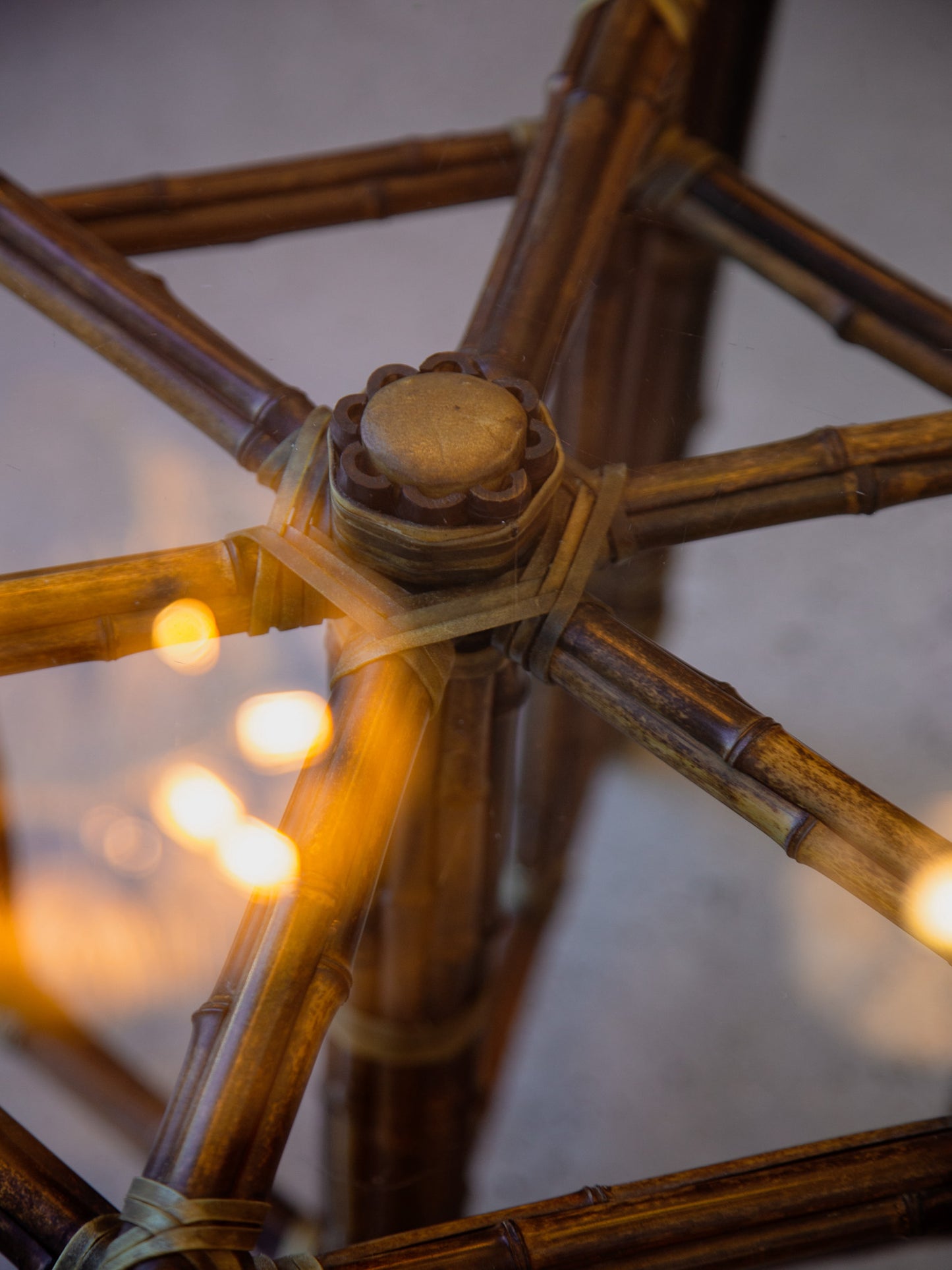 Close-up of a bamboo structure with blurred lights in the background