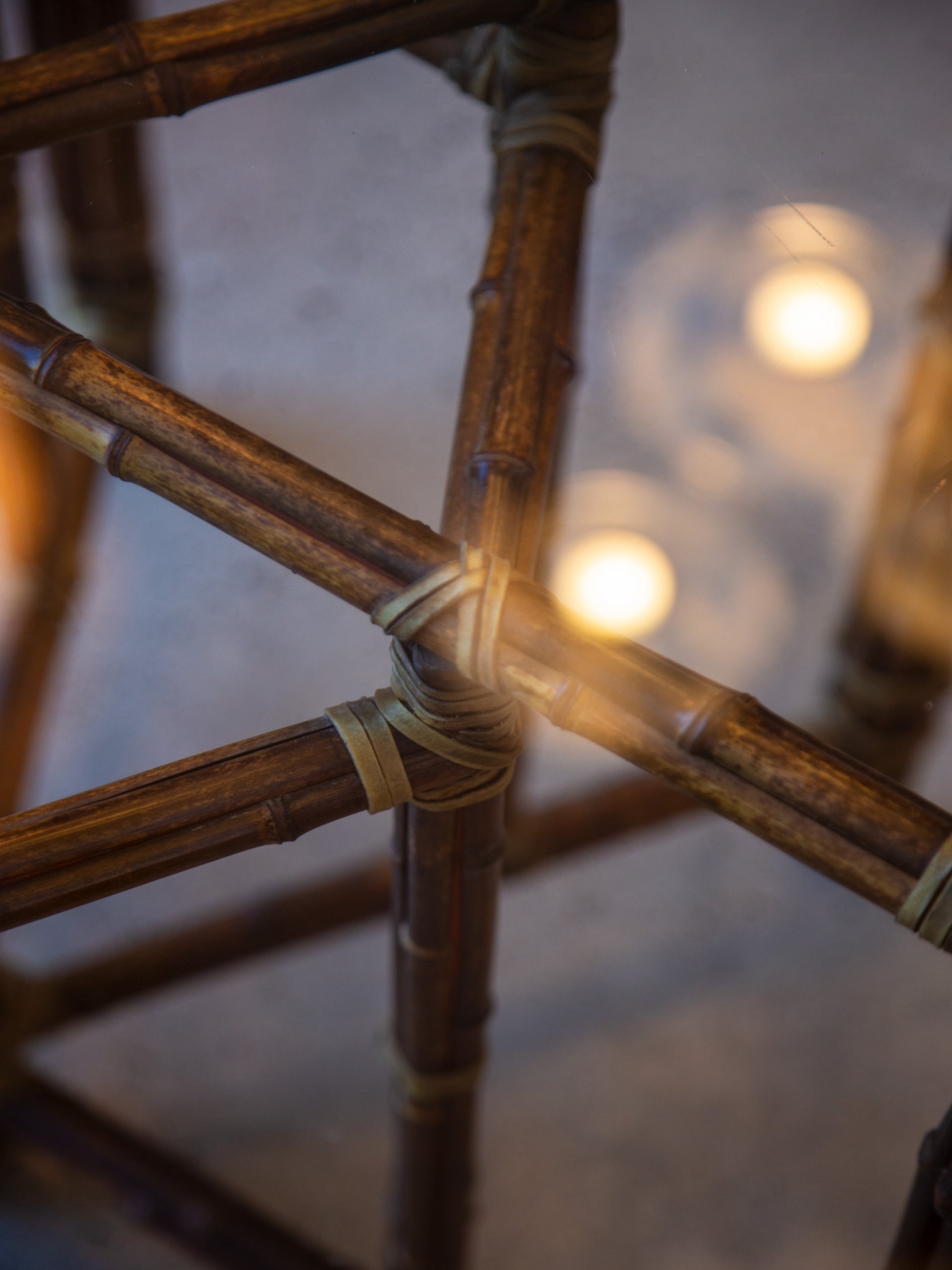 Close-up of a woven bamboo chair with blurred lights in the background