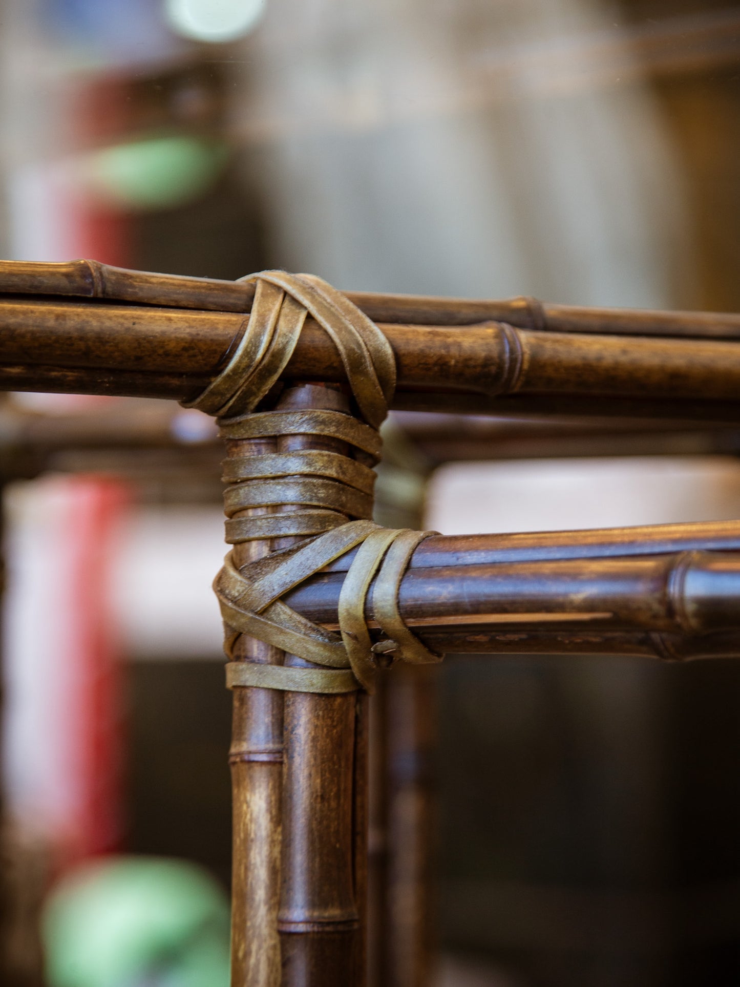Close-up of a bamboo structure with a rubber band wrapped around it, blurred background