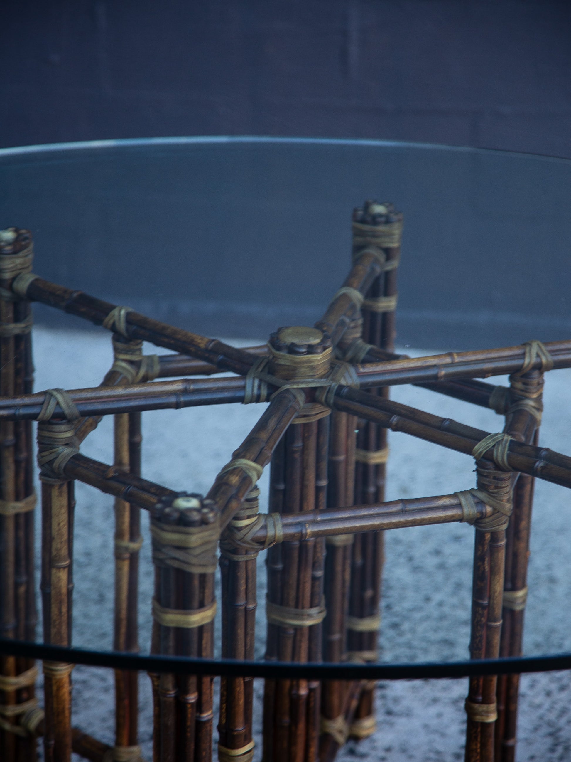 Glass table with a bamboo-like frame on a textured surface