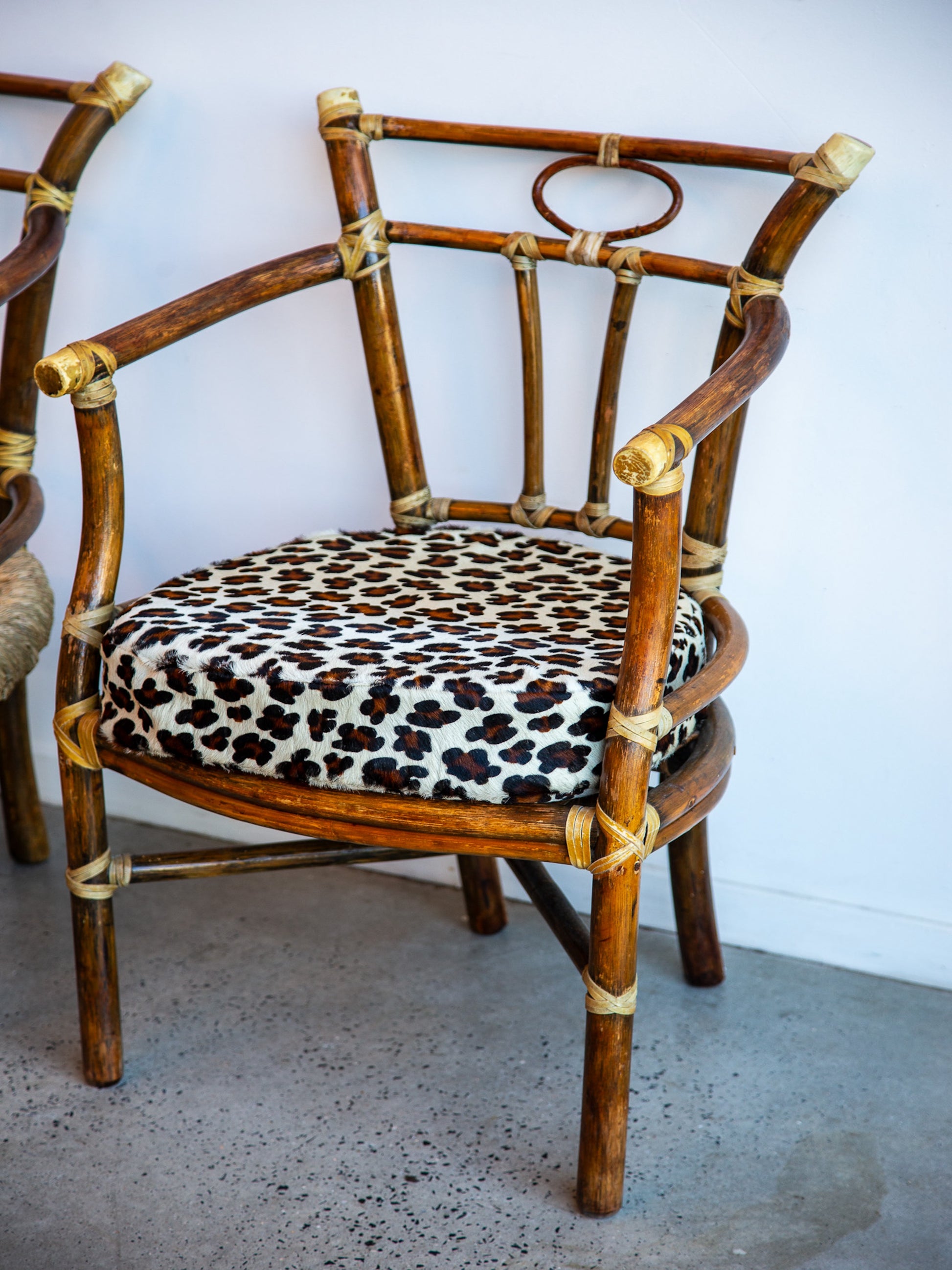 Rattan chair with leopard print cushion against a white wall