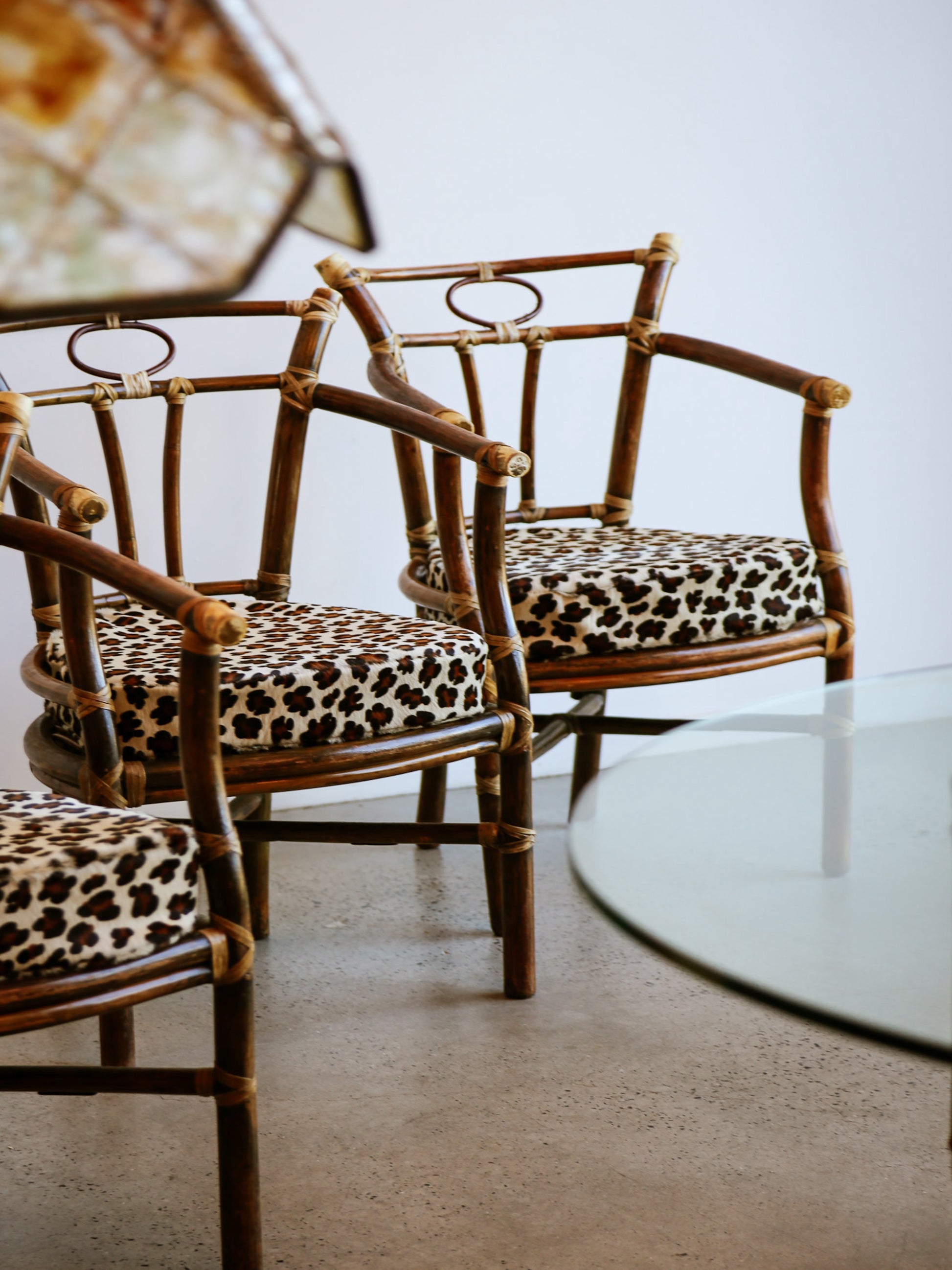 Rattan chairs with leopard print cushions in a minimalistic room.