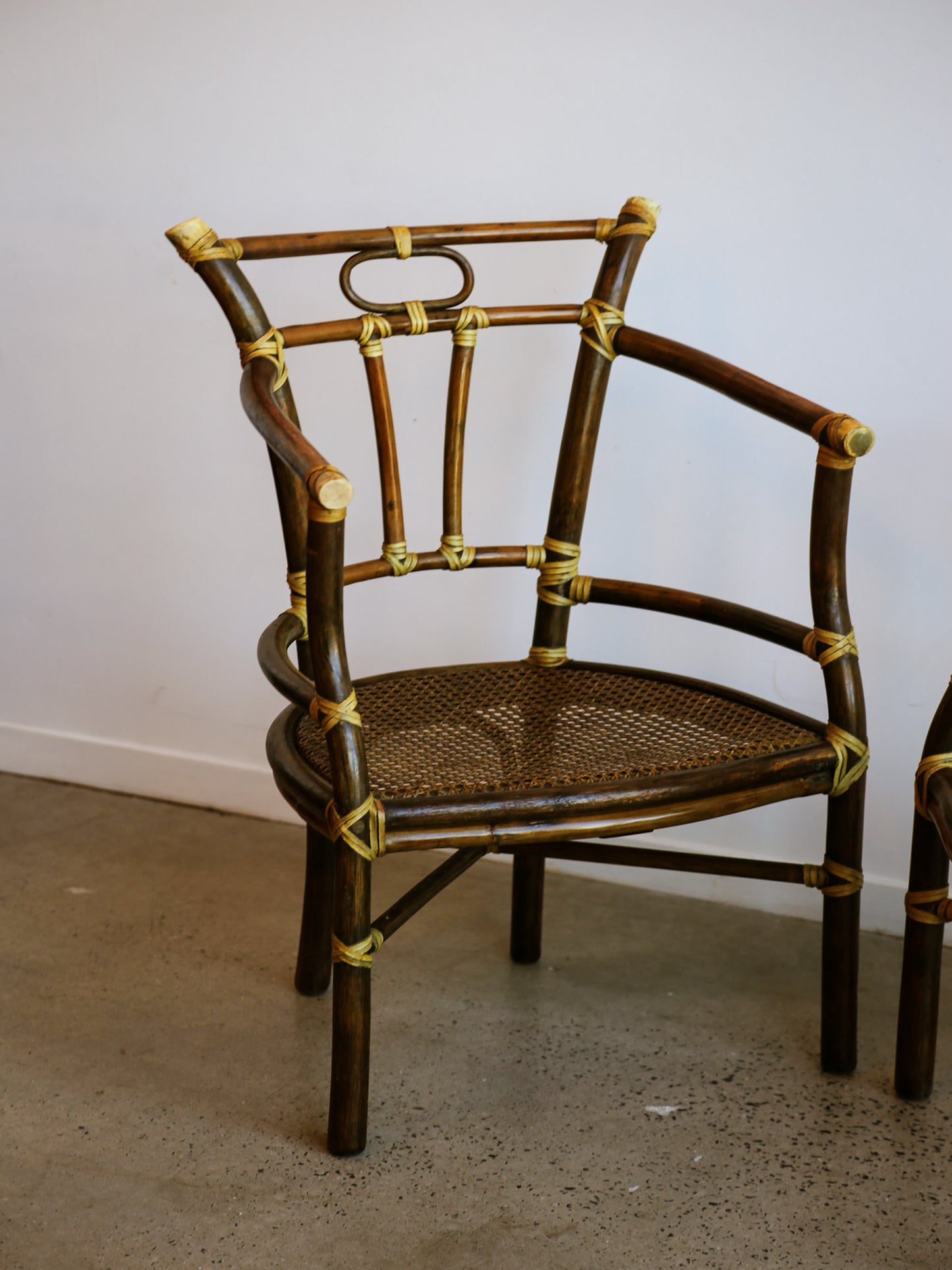 Rattan chair with woven seat against a white wall
