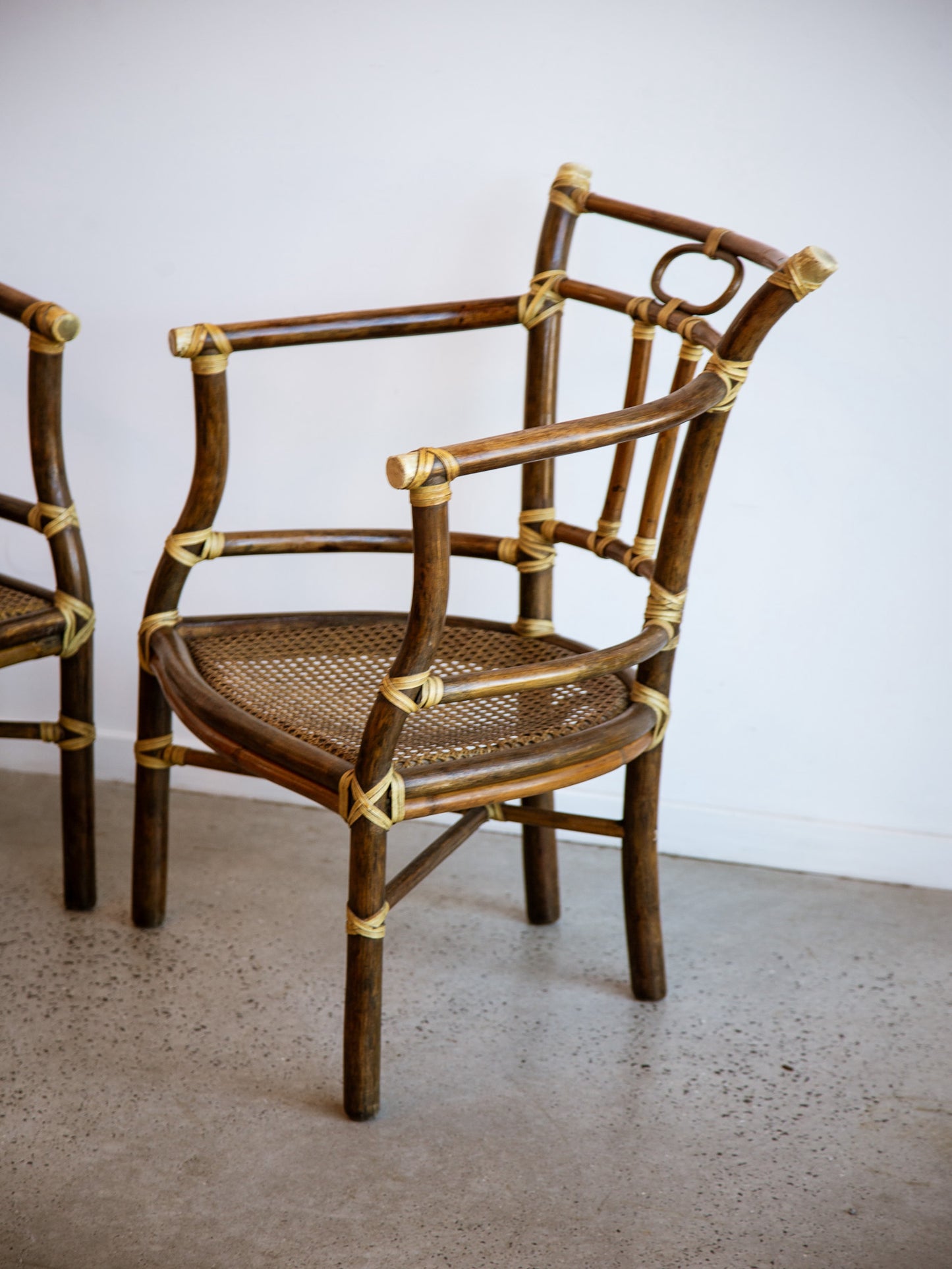 Rattan chair with woven seat on a plain floor and wall background