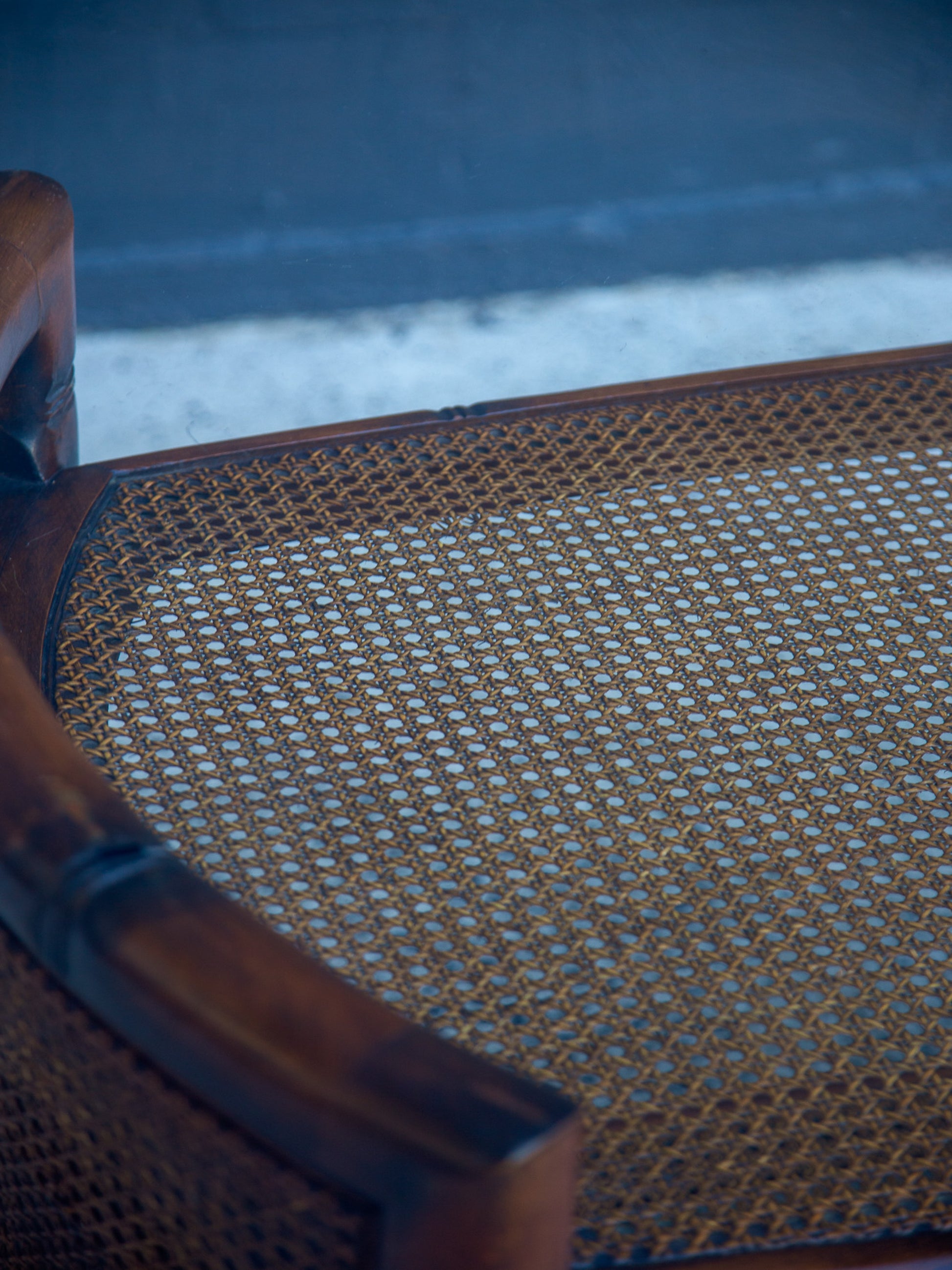 Close-up of a wicker chair seat with a blurred background