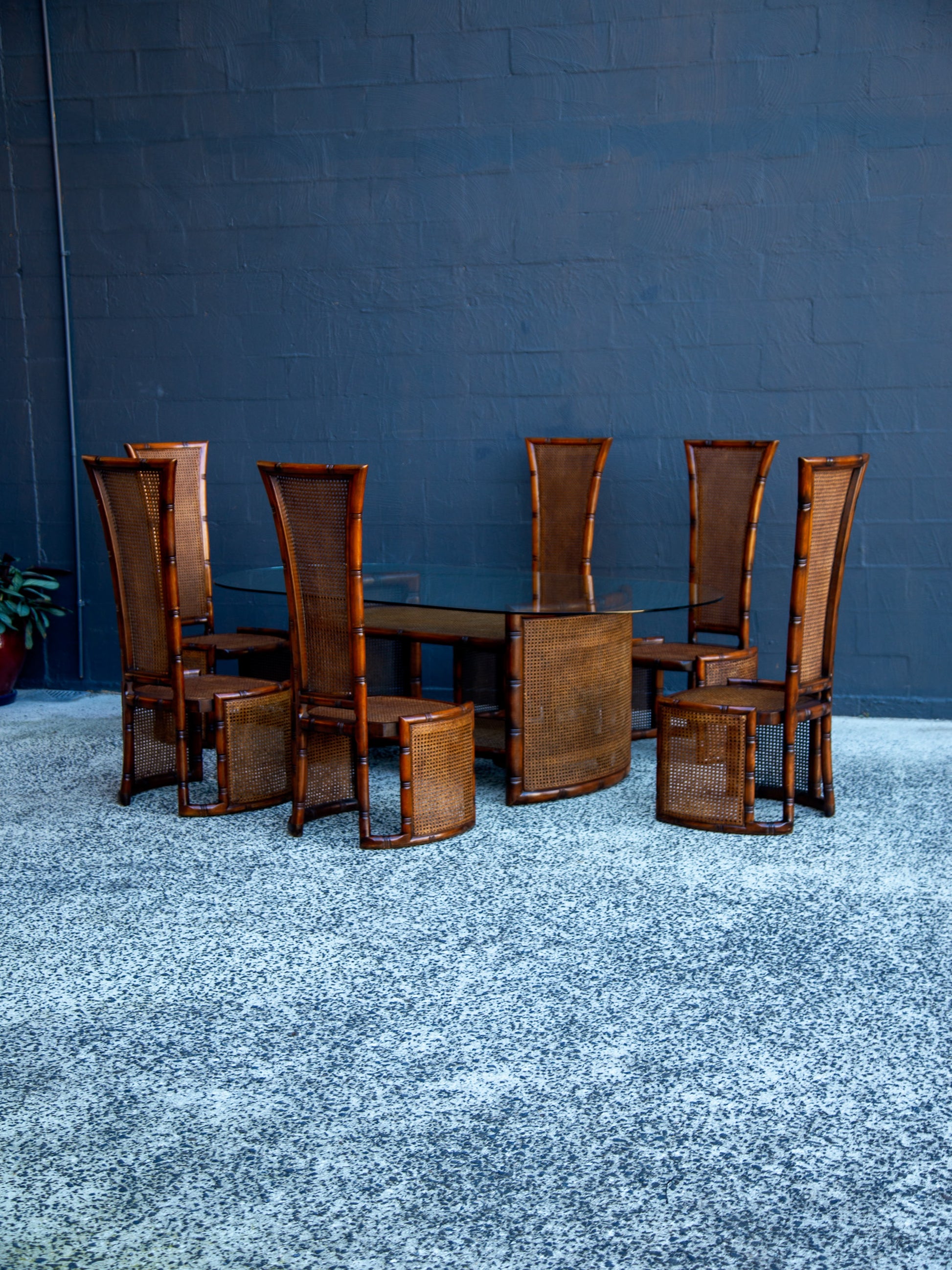 Wooden dining table with chairs against a blue wall