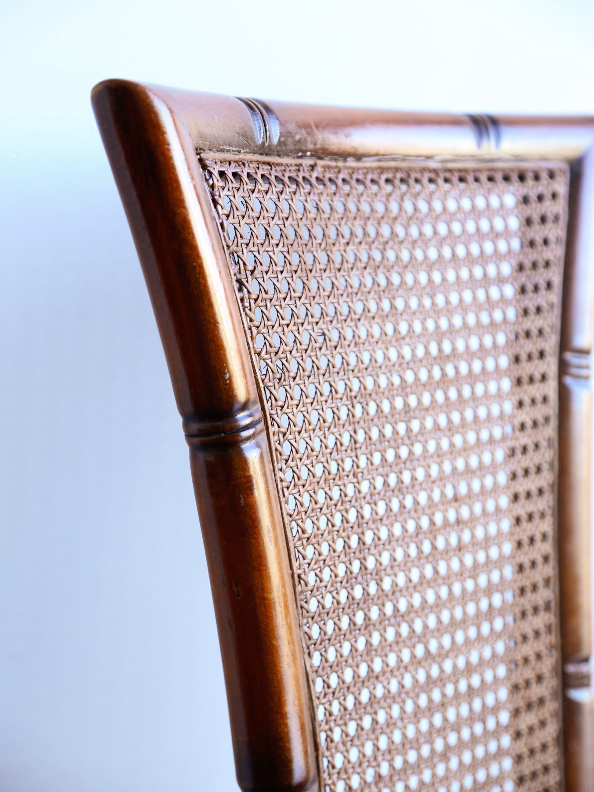 Close-up of a chair with woven backrest and wooden frame on a white background