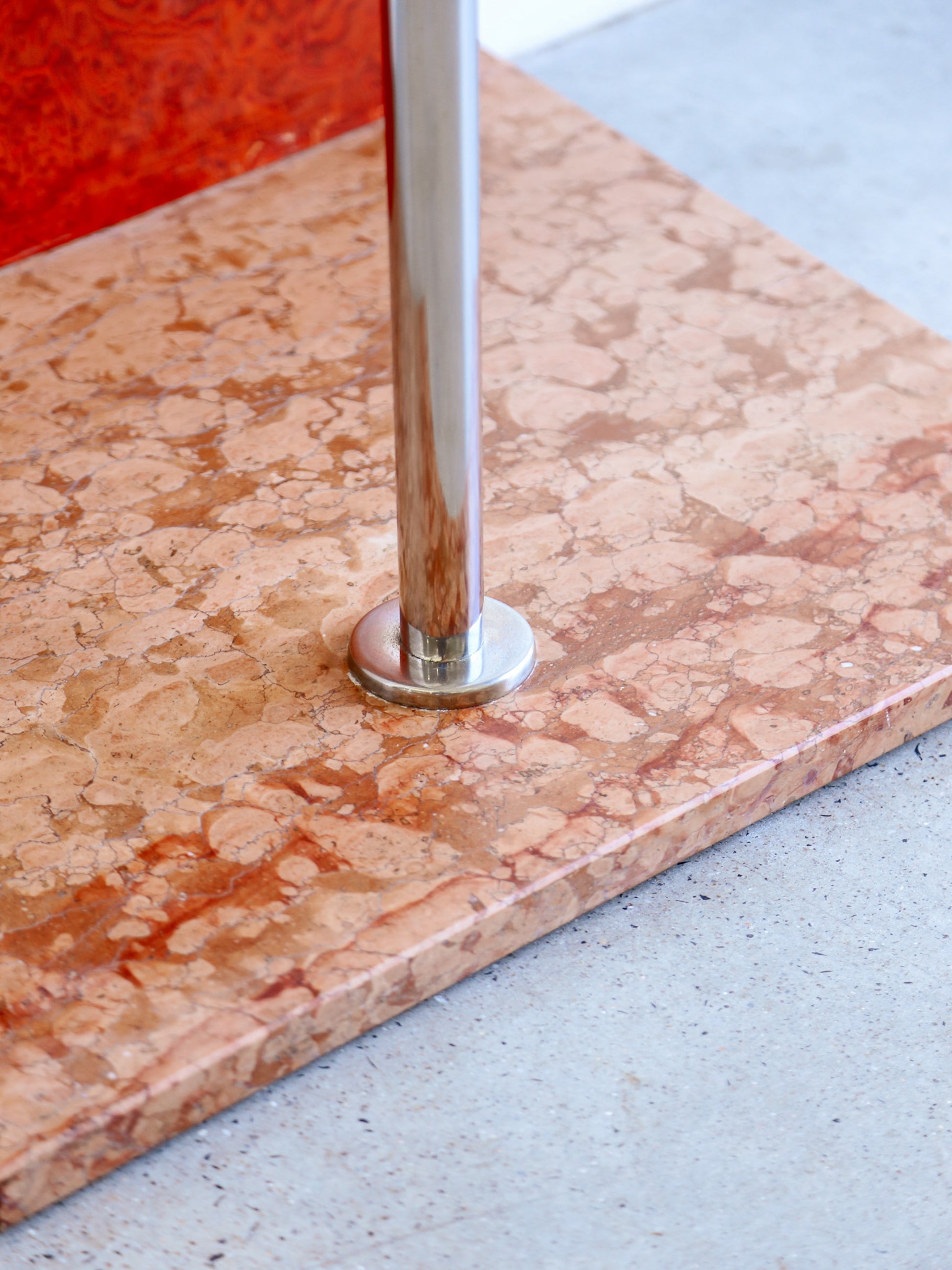 Close-up of a marble surface with a metal leg